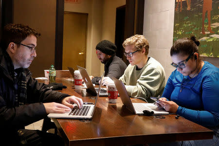 Customers use the internet at a Starbucks in the financial district in New York City, U.S., December 14, 2017. REUTERS/Brendan McDermid