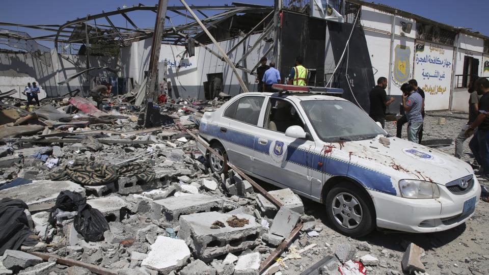 Debris covers the ground and an emergency vehicle after an airstrike at a detention center in Tajoura, east of Tripoli in Libya, Wednesday, July 3, 2019. An airstrike hit the detention center for migrants early Wednesday, killing several. (AP Photo/Hazem Ahmed)