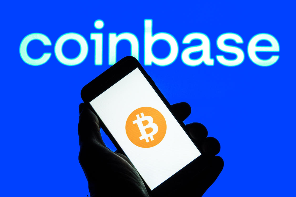 SPAIN - 2022/01/12: In this photo illustration a Bitcoin logo seen displayed on a smartphone with a Coinbase logo in the background. (Photo Illustration by Thiago Prudencio/SOPA Images/LightRocket via Getty Images)