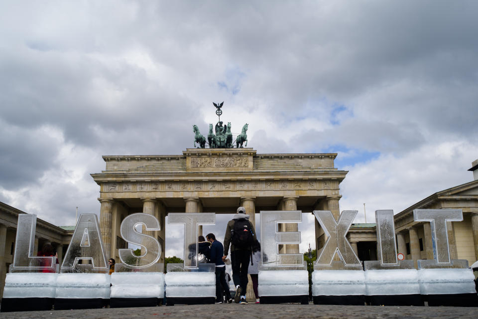 Climate activists of the Greenpeace organisation protest with big ice blocks reading 'Last Exit' in front of the Brandenburg Gate in Berlin, Tuesday, May 14, 2019. The protest is in reference to the Petersberg climate talks. (AP Photo/Markus Schreiber)