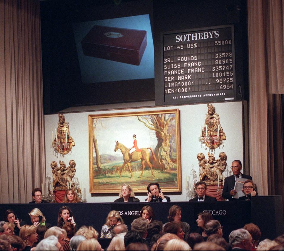 NEW YORK, UNITED STATES:  Sotheby&#39;s employees take telephone bids from Chicago and Los Angeles on the red leather dispatch box of King Edward VIII, seen in photo at top, on the first night of the auction of the contents of the Paris residence of the Duke and Duchess of Windsor 19 February. This item brought 57,500 USD, well above its catalog estimate of 10,000 to 15,000 USD.   AFP PHOTO/Henny Ray ABRAMS (Photo credit should read HENNY RAY ABRAMS/AFP via Getty Images)