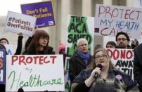 Laura Hayes (with microphone), of Fort Wayne, Indiana tells fellow protestors how the Affordable Care Act helped her with health costs, during a protest in front of the Supreme Court in Washington March 4, 2015. REUTERS/Gary Cameron