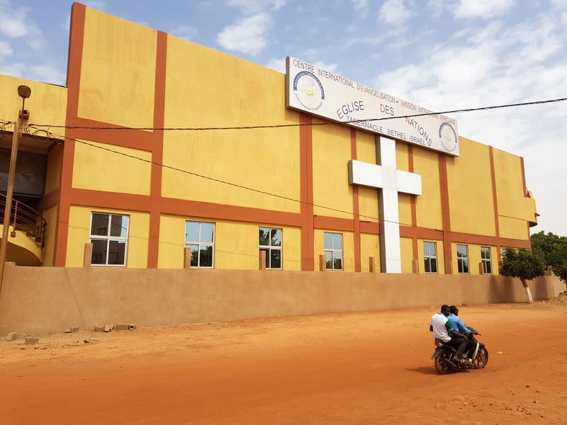 People ride motocycle past closed Centre International d'Evangelisation in Ouagadougou