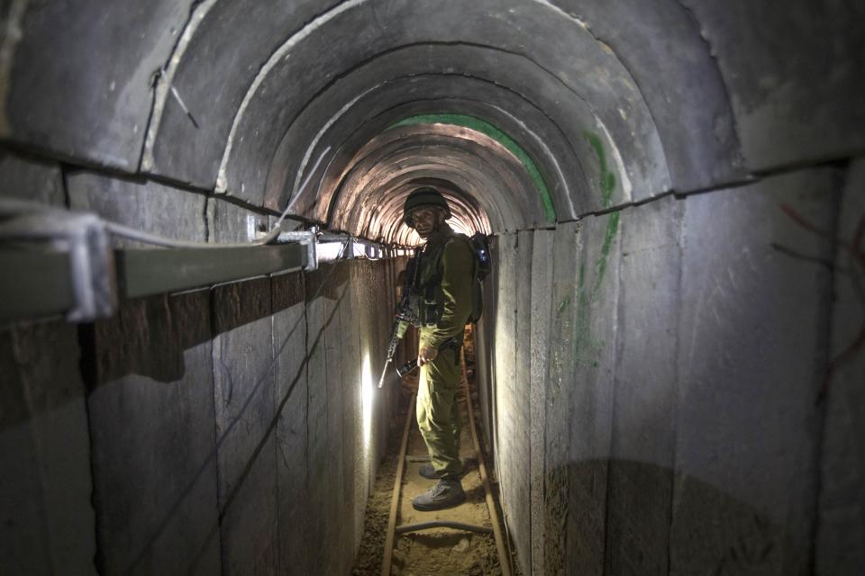 FILE - In this Friday, July 25, 2014 file photo, an Israeli army officer gives journalists a tour of a tunnel allegedly used by Palestinian militants for cross-border attacks, at the Israel-Gaza Border.