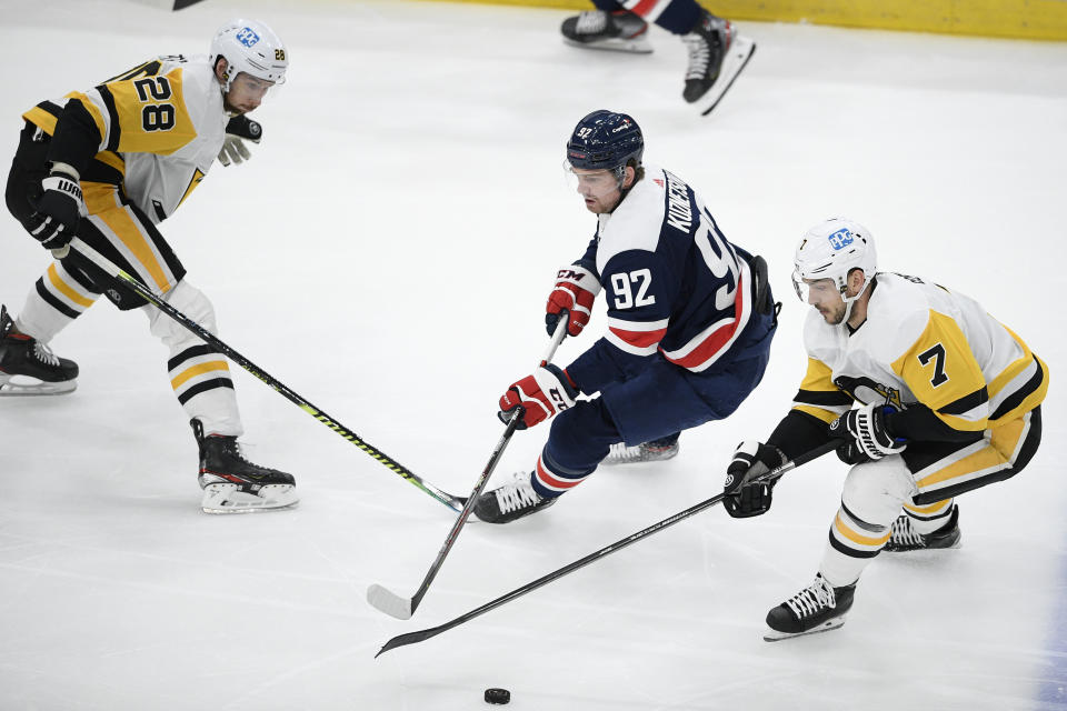 Pittsburgh Penguins defenseman Marcus Pettersson (28) and right wing Colton Sceviour (7) compete for the puck against Washington Capitals center Evgeny Kuznetsov (92) during the first period of an NHL hockey game Saturday, May 1, 2021, in Washington. (AP Photo/Nick Wass)