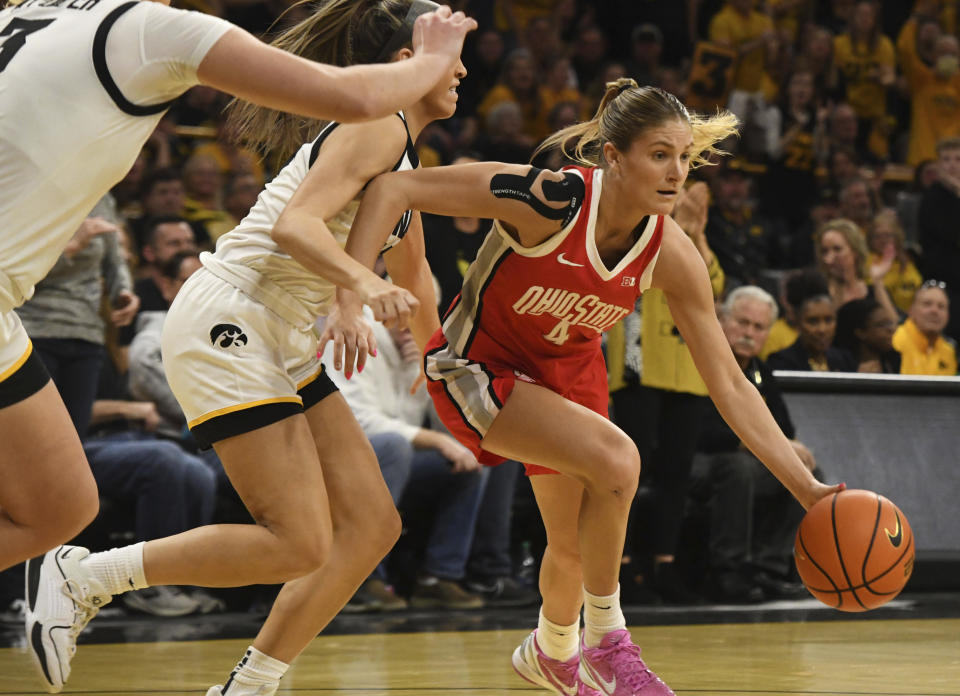 Ohio State guard Jacy Sheldon (4) drives toward the basket under pressure from Iowa guard Gabbie Marshall, second from right, during the first half of an NCAA college basketball game, Sunday, March 3, 2024, in Iowa City, Iowa. (AP Photo/Cliff Jette)