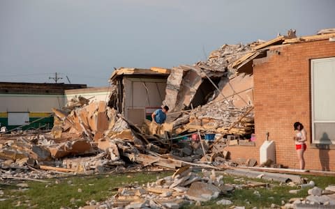 People look on as they examine the damaged remains of school in Dayton, Ohio - Credit: AFP