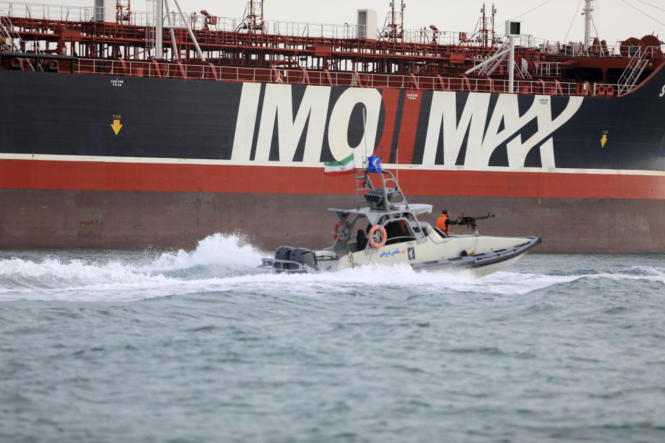 In this Sunday, July 21, 2019 photo, a speedboat of the Iran's Revolutionary Guard moves around a British-flagged oil tanker Stena Impero which was seized in the Strait of Hormuz on Friday by the Guard, in the Iranian port of Bandar Abbas. Global stock markets were subdued Monday while the price of oil climbed as tensions in the Persian Gulf escalated after Iran's seizure of a British oil tanker on Friday. (Morteza Akhoondi/Mehr News Agency via AP)