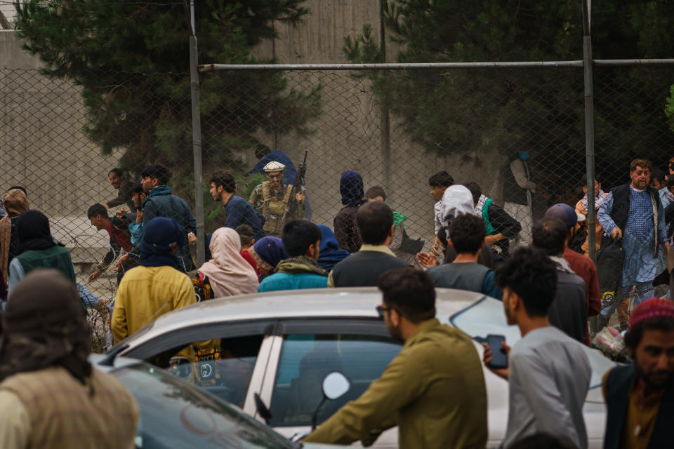 KABUL, AFGHANISTAN -- AUGUST 17, 2021: Taliban fighters use guns fire, whips, sticks and sharp objects to maintain crowd control over thousands of Afghans who continue to wait outside the Kabul Airport for a way out, on airport road in Kabul, Afghanistan, Tuesday, Aug. 17, 2021.  (MARCUS YAM / LOS ANGELES TIMES)