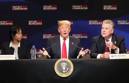 U.S. President Donald Trump speaks during a roundtable on immigration and the gang MS-13 as he sits between Evelyn Rodriguez, whose daughter was killed ny MS-13 gang members and U.S. Rep. Peter King (R-NY) at the Morrelly Homeland Security Center in Bethpage, New York, U.S., May 23, 2018. REUTERS/Kevin Lamarque