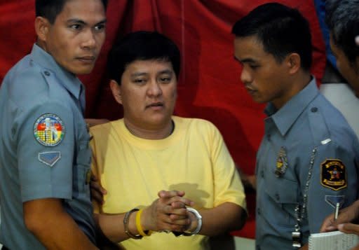 Detained Maguindanao massacre suspect Andal Ampatuan Jnr. (C) is escorted by policemen back to his cell in Manila. Andal Ampatuan Jnr, allegedly led his family's private army in stopping a convoy carrying the wife and relatives of a political rival, lawyers and a group of 32 journalists, and then gunning them down on a grassy hill