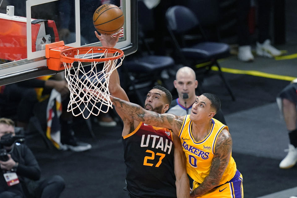 Utah Jazz center Rudy Gobert (27) scores against Los Angeles Lakers forward Kyle Kuzma (0) during the first half of an NBA basketball game Wednesday, Feb. 24, 2021, in Salt Lake City. (AP Photo/Rick Bowmer)