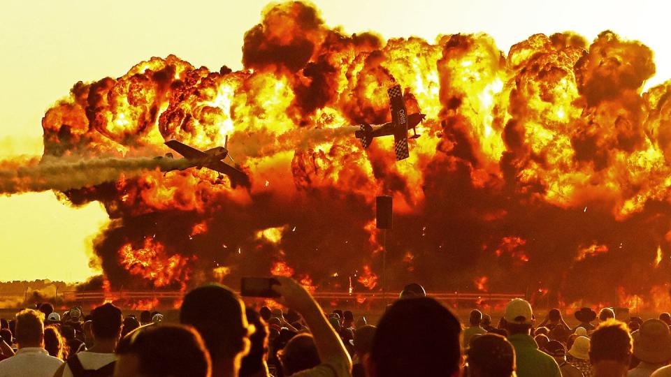 Oris TinStix of the Dynamite aerobatic team featuring American Skip Stewart and Triple world aerobatics champion Jurgus Kairys fly past pyrotechnics as they perform at a 2017 air show in Avalon, Australia. (Scott Barbour/Getty Images)