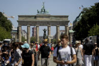 A demonstrator carries a sign reading 'Freedom' in front of the Brandenburg gate as he attends a demonstration with the slogan ‚The end of the pandemic - freedom day' - against coronavirus restrictions in Berlin, Germany, Saturday, Aug. 1, 2020. It comes amid increasing concern about an upturn in infections in Germany. (AP Photo/Markus Schreiber)