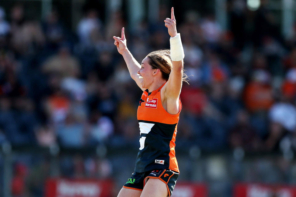 Chloe Dalton with two hands up playing AFL.