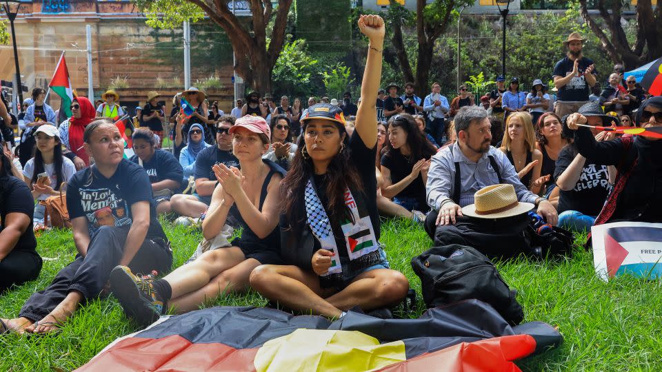 Protesters carry the Aboriginal flag as Indigenous leaders speak about the injustices inflicted through colonization. - Jenny Evans/Getty Images