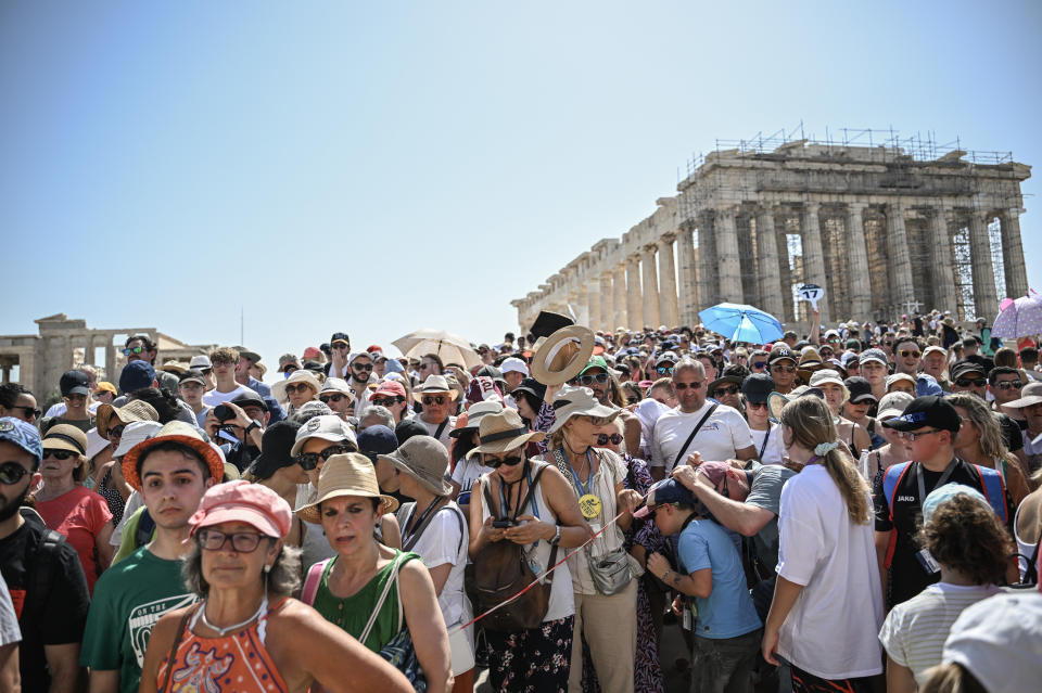 dpatop - 14 July 2023, Greece, Athen: A large crowd of tourists visit the Parthenon Temple on the Acropolis Hill on this hot day. The Ministry of Culture has decided to close the archaeological site during the hottest hours of the day, from 12 to 5 p.m., as Greece is currently experiencing a heat wave. Photo: Angelos Tzortzinis/dpa (Photo by Angelos Tzortzinis/picture alliance via Getty Images)