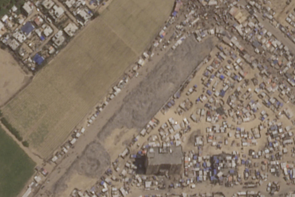 This June 21, 2024, image provided by Planet Labs PBC shows an informal landfill, center, in the city of Khan Younis that sprung up after Oct. 7 appears to have doubled in length since January. Since the Rafah evacuation, a tent city has sprung up around the landfill, with Palestinians living in between piles of garbage. (Planet Labs PBC via AP)