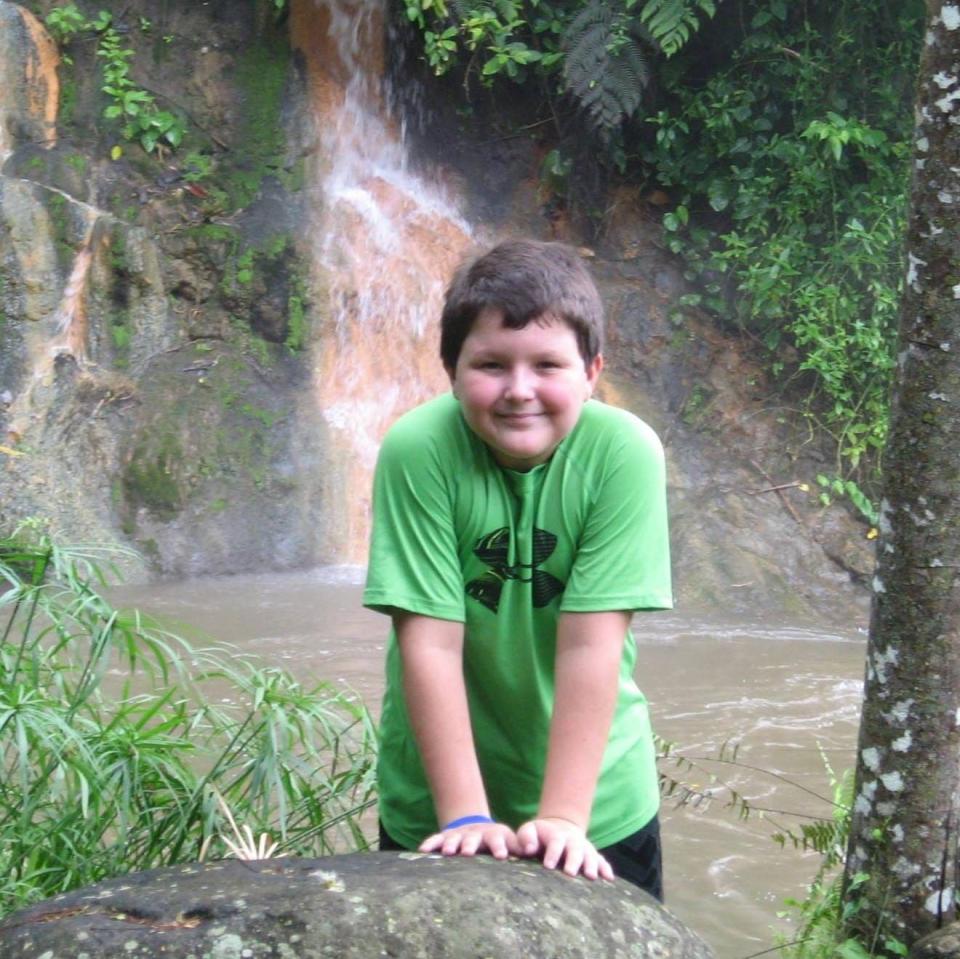 Jordan Smelski smiling at the camera on vacation in front of a natural pool of water