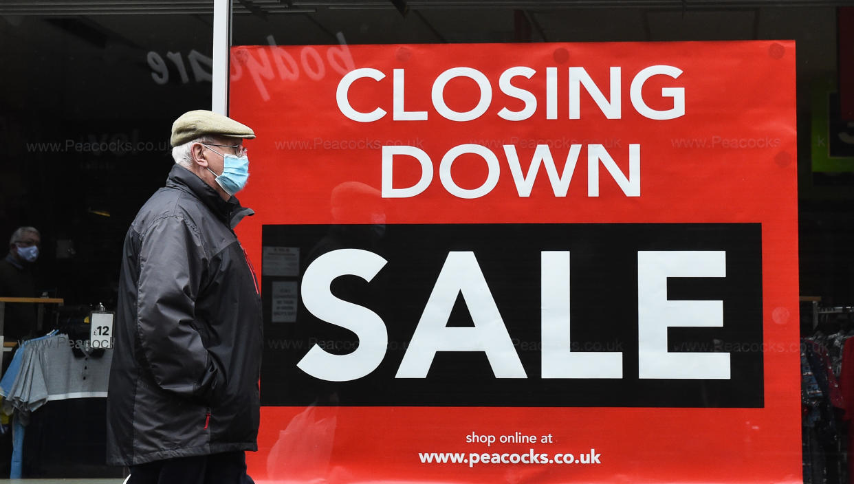 NEWCASTLE-UNDER-LYME, ENGLAND - NOVEMBER 20: A man walks past a branch of Peacocks clothing store on November 20, 2020 in Newcastle-Under-Lyme, England. The chain is among a number of businesses to announce their closure, blaming the inability to survive the financial impact of national lockdowns and social restrictions. (Photo by Nathan Stirk/Getty Images)