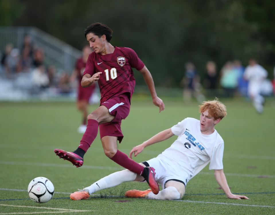Arlington's Anthony Cocca evades a slide tackle from John Jay's Seamus Fulton during a September 13, 2023 boys soccer game.