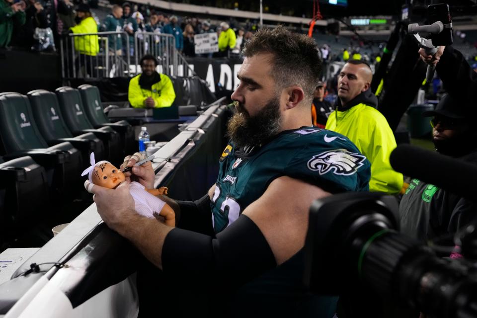 Philadelphia Eagles center Jason Kelce autographs a doll following an NFL divisional round playoff game against the New York Giants on Saturday, Jan. 21, 2023, in Philadelphia. The Eagles won 38-7.
