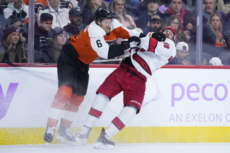 Philadelphia Flyers' Travis Sanheim, left, and Carolina Hurricanes' Jordan Martinook collide during the third period of an NHL hockey game, Tuesday, Nov. 28, 2023, in Philadelphia. (AP Photo/Matt Slocum)