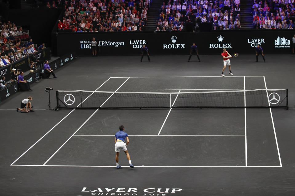 Team World's Kevin Anderson, top, hits a return to Team Europe's Novak Djokovic, bottom, at the Laver Cup tennis event, Saturday, Sept. 22, 2018, in Chicago. (AP Photo/Kamil Krzaczynski)