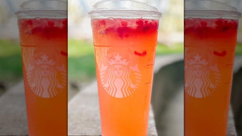 An orange and red Starbucks Refresher beverage