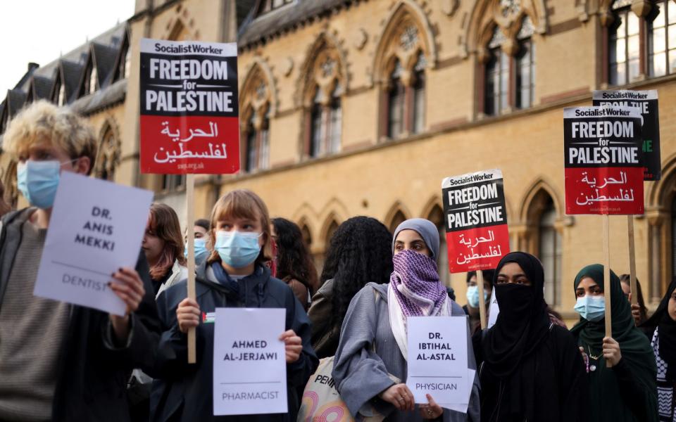 Protesters hold signs outside the Oxford University Museum of Natural History