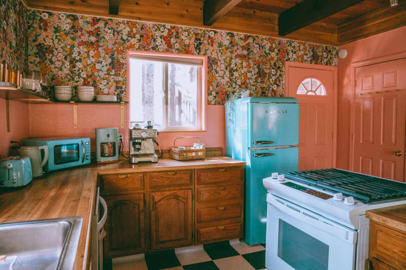 Vintage inspired green refrigerator in pink and green kitchen.