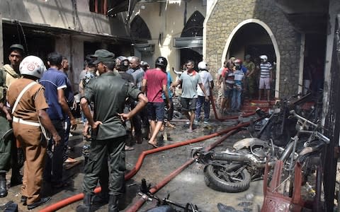 Locals and police gather at the Secon church - Credit: M A Pushpa Kumara/Rex