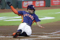 Houston Astros' Jose Altuve slides into home plate as he scores on a one run RBI double by Kyle Tucker against the Oakland Athletics in the first inning of a baseball game Wednesday, May 15, 2024, in Houston. (AP Photo/Michael Wyke)