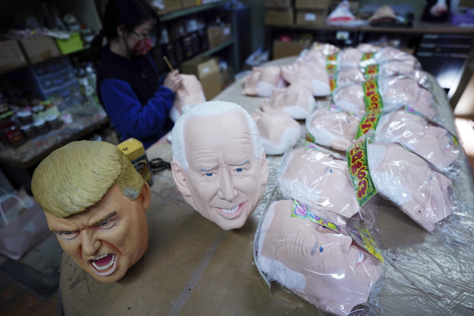 Near the finish products of rubber masks depicting President-elect Joe Biden and President Donald Trump, an employee adds details to the rubber masks at the Ogawa Studios in Saitama, north of Tokyo, Wednesday, Nov. 11, 2020. Ogawa Studios, a Japanese manufacturer started making the masks since the middle of October, ahead of last week's election. (AP Photo/Eugene Hoshiko)