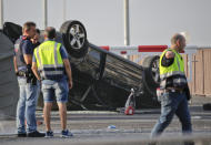 <p>Police officers walk near an overturned car onto a platform at the spot where terrorists were intercepted by police in Cambrils, Spain, Friday, Aug. 18, 2017. The police force for Spain’s Catalonia region says the five suspects shot and killed in the resort town of Cambrils were carrying bomb belts, which have been detonated by the force’s bomb squad. (Photo: Emilio Morenatti/AP) </p>
