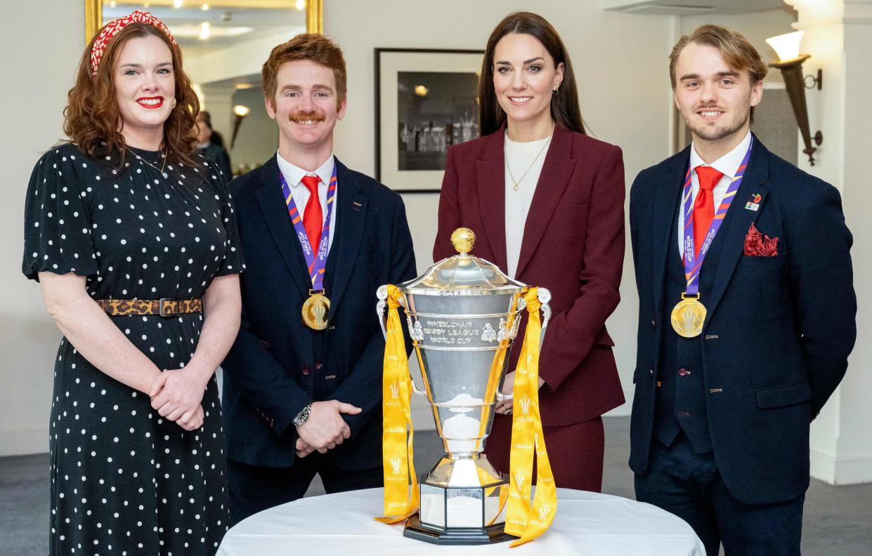 Britain's Catherine, Princess of Wales (2R) stands with England's James Simpson (2L), England head coach Tom Cold (R) and Josie Hill, as they pose with the Rugby League World Cup trophy, during a reception in recognition of the success of the England Wheelchair Rugby League team at the recent Rugby League World Cup, at Hampton Court Palace in southwest London on January 19, 2023. (Photo by Mark Large / POOL / AFP) (Photo by MARK LARGE/POOL/AFP via Getty Images)