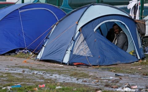 A migrant wakes up in a shelter tent in the port city of Calais, France February 2, 2018.  - Credit: PASCAL ROSSIGNOL/REUTERS