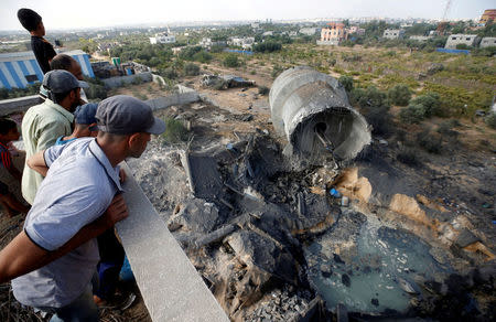 Palestinians look at damage at the site of an Israeli air strike in Al-Mughraqa on the outskirts of Gaza City August 9, 2018. REUTERS/Mohammed Salem