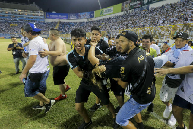 An injured fan in carried to the field of Cuscatlan stadium in San Salvador, El Salvador, Saturday, May 20, 2023. At least nine people were killed and dozens more injured when stampeding fans pushed through one of the access gates at a quarterfinal Salvadoran league soccer match between Alianza and FAS. (AP Photo/Milton Flores)