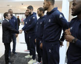 French President Emmanuel Macron, left, shakes hands with national team players as he arrives to inaugurate a new handball stadium in Creteil, on the outskirts of Paris, Wednesday, Jan. 9, 2019. About 200 protesters, including unionists and yellow vests, gathered Wednesday in Creteil, a Paris suburb, as Macron was doing a visit in a facility dedicated to handball. Some scuffles broke out with police forces that used tear gas to keep the crowd at a distance from the French leader. (Ludovic Marin, Pool via AP)