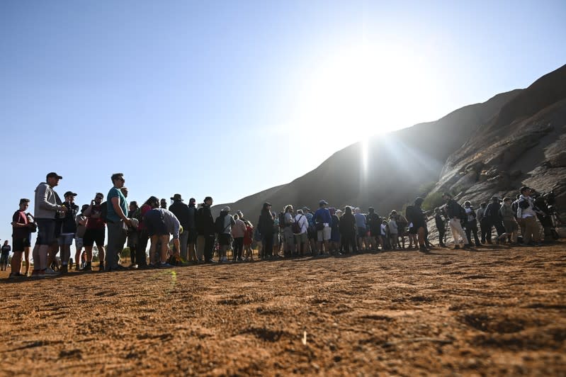 Tourists line up to climb Uluru, formerly known as Ayers Rock, at Uluru-Kata Tjuta National Park in the Northern Territory