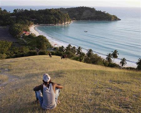 A man looks out over Abaka Bay, where one of the island's two boutique hotels is located, on the western side of Ile-a-Vache island, off Haiti's south coast, March 25, 2014. REUTERS/stringer