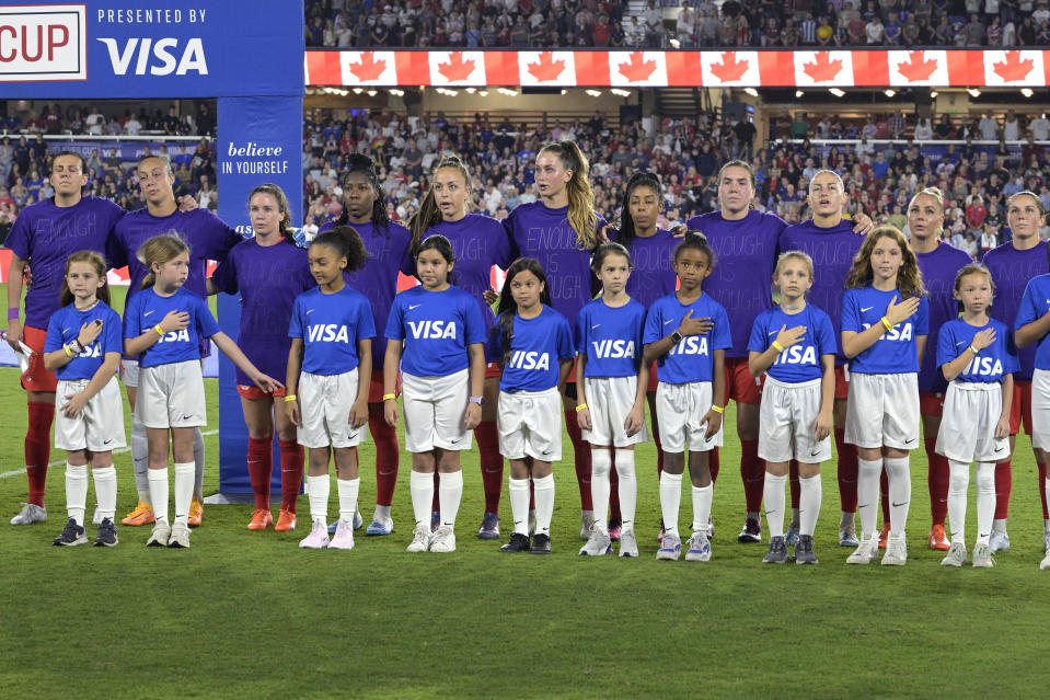 Canada players wear purple shirts with "Enough is Enough" written on them during the Canadian national anthem before the team's SheBelieves Cup women's soccer match against the United States, Thursday, Feb. 16, 2023, in Orlando, Fla. (AP Photo/Phelan M. Ebenhack)