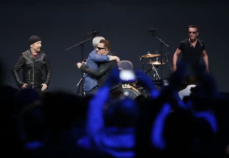 Apple CEO Tim Cook embraces Bono of U2 during an Apple event announcing the iPhone 6 and the Apple Watch at the Flint Center in Cupertino, California, September 9, 2014. REUTERS/Stephen Lam
