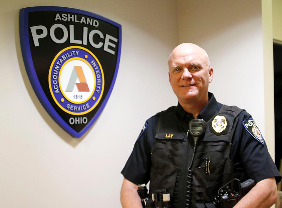 Ashland Police Chief Dave Lay poses next to the Ashland Police Department logo in the administrative offices on Thursday, June 24, 2021. TOM E. PUSKAR/TIMES-GAZETTE.COM