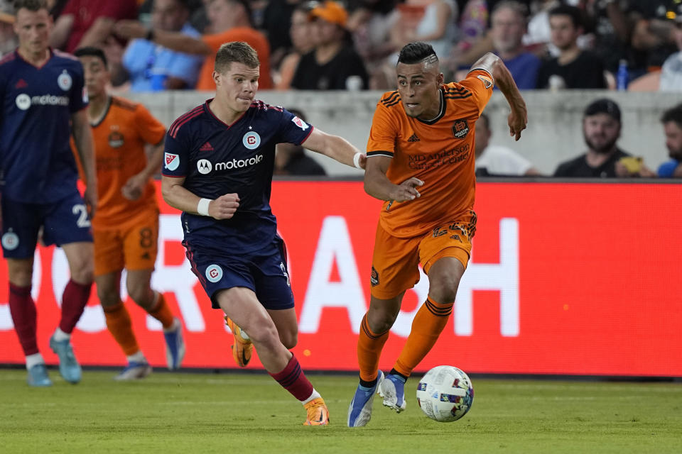Houston Dynamo's Darwin Cerén (24) controls the ball as Chicago Fire's Chris Mueller (8) defends during the second half of an MLS soccer game Saturday, June 25, 2022, in Houston. (AP Photo/David J. Phillip)