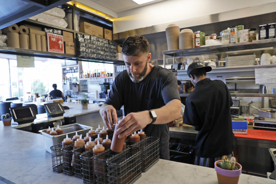 In this Sept. 12, 2019 photo, Chris Miles helps to prepare his restaurant, Batesy's, for opening in the Rockaway section of New York. Miles and partners were ready to open their new, seaside barbecue joint just in time for the summer season when they got stunning news: There would be no gas to fuel the fryers, griddles and stoves. National Grid has imposed a moratorium on new gas hookups in parts of New York City, saying it can’t meet rising demand without the new pipeline. (AP Photo/Seth Wenig)