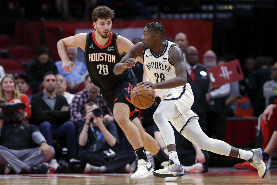 Brooklyn Nets forward Dorian Finney-Smith, right, drives around Houston Rockets center Alperen Sengun, left, during the first half of an NBA basketball game Wednesday, Jan. 3, 2024, in Houston. (AP Photo/Michael Wyke)