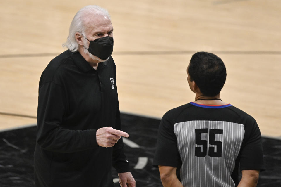 El entrenador de los Spurs de San Antonio Gregg Popovich habla con el referee Bill Kennedy durante la segunda mitad del juego ante los Warriors de Golden State, el lunes 8 de febrero de 2021, en San Antonio. (AP Foto/Darren Abate)