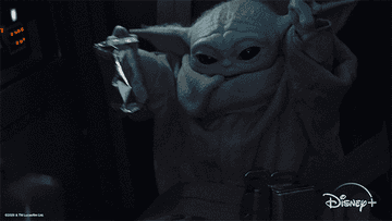 Baby Yoda waving arms in the air happily